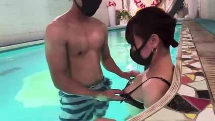 Азиаты в масках ласкаются в бассейне